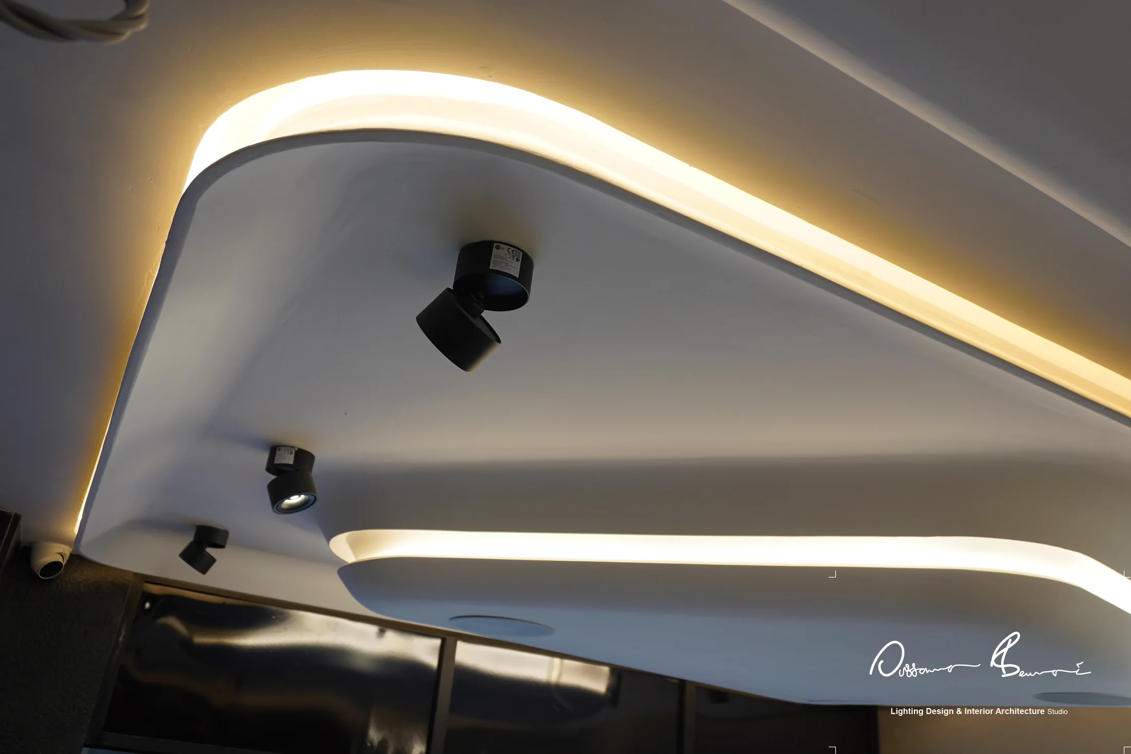 Detalle de plafón con luz indirecta cálida y focos orientables